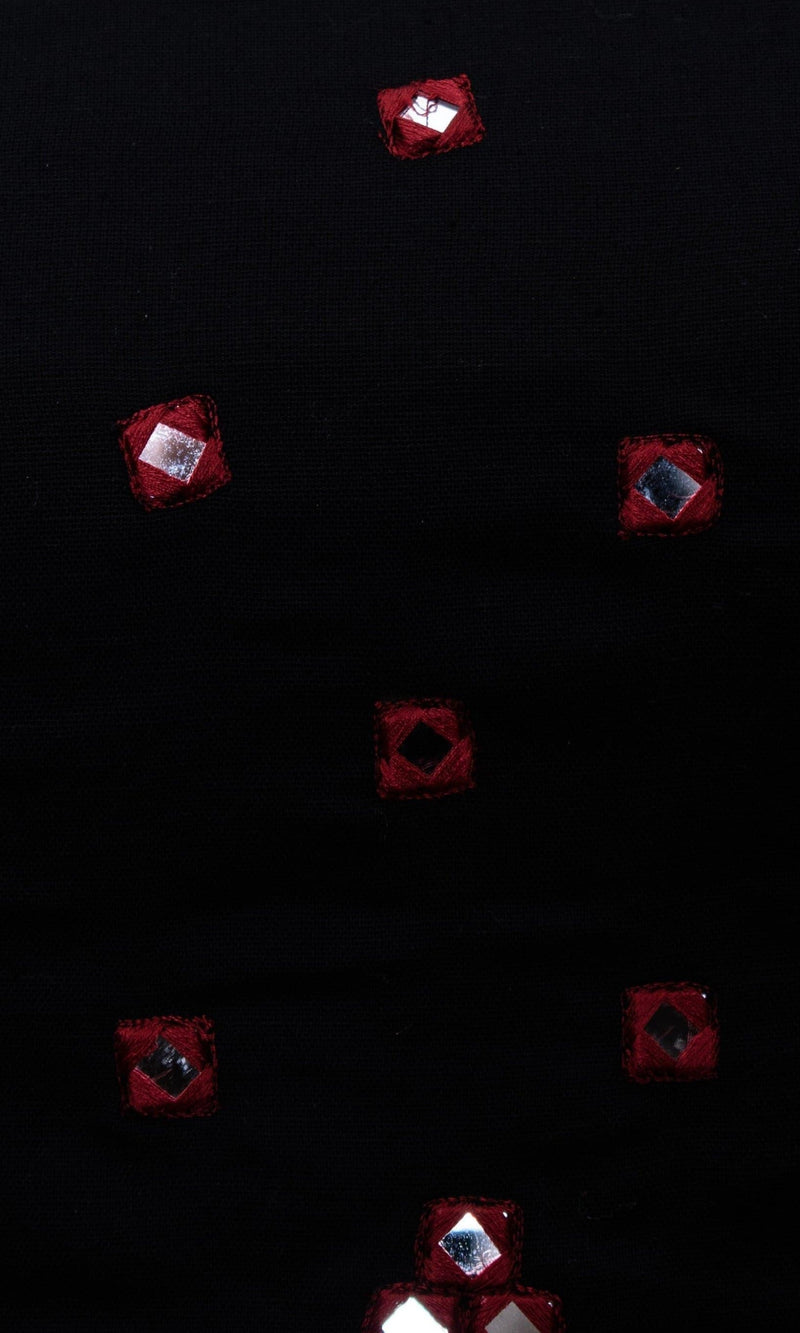 Black cotton fabric with scattered red hand-embroidered mirror work, perfect for Garba styles.