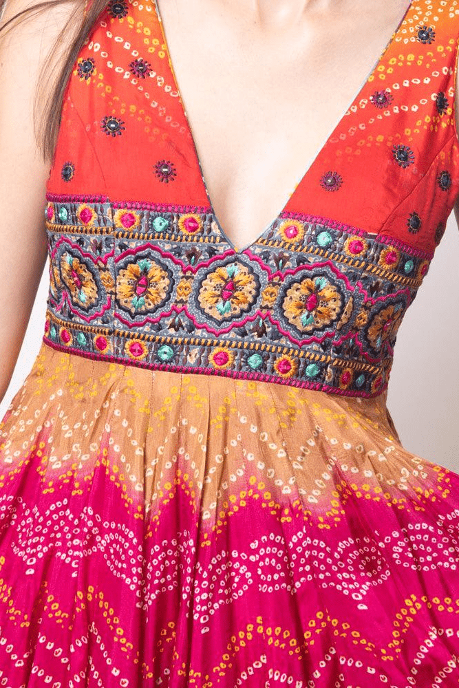 Silk long dress with vibrant bandhani print, embroidered bodice, and deep V-neck.