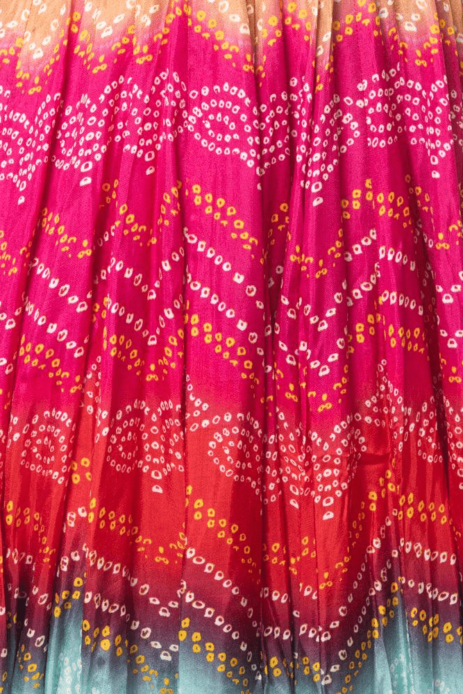 Vibrant silk long dress with a flowing, multi-hued bandhani print.