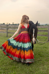 Silk Leandra Long Dress with embroidered top and vibrant bandhani print, worn by a woman next to a horse.