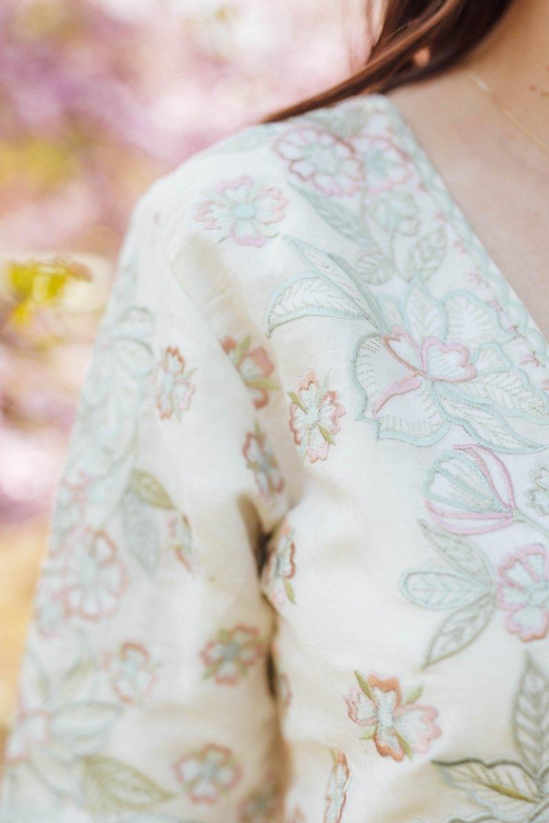 Off-white linen midi dress with delicate pink and green floral resham hand embroidery.