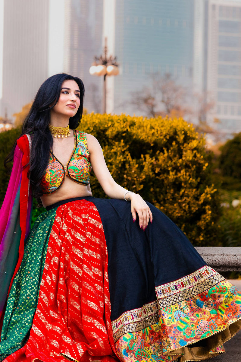 Woman in a multi-color silk Chaniya Choli with a black full-flare lehenga, embroidered blouse, and georgette dupatta.