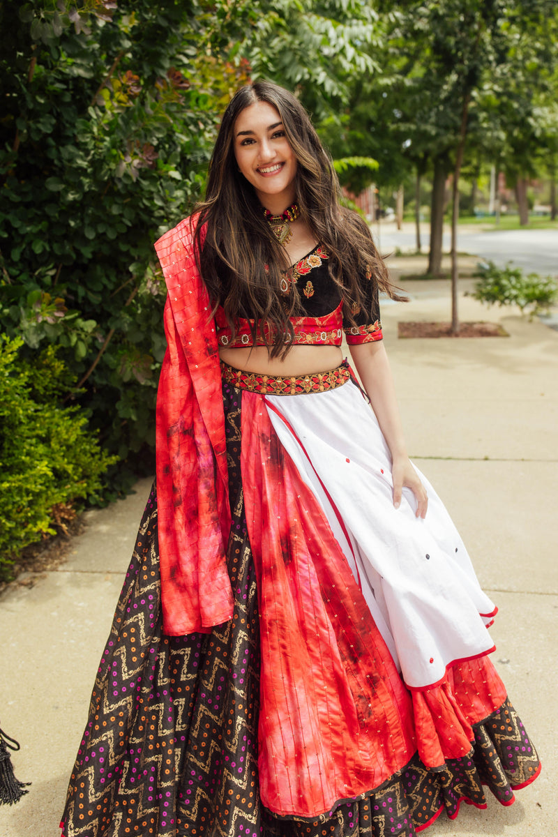 Multi-color layered chaniya choli with red, white, black, mirror work, and sequin details, perfect for dramatic twirls.