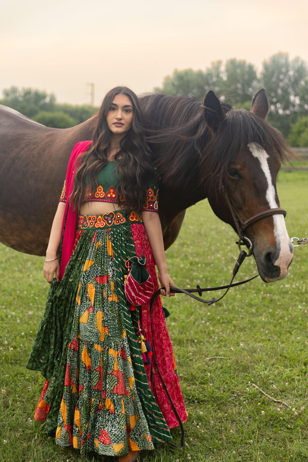 Multicolor full flare Chaniya Choli set with kachi embroidery, U-back blouse, and georgette dupatta, next to a horse.