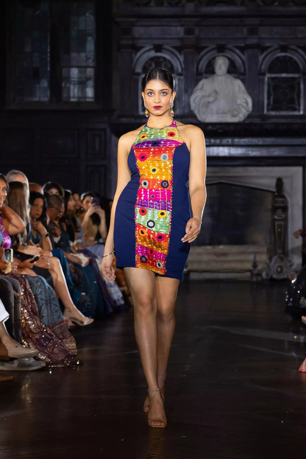 Model in a navy multicolor short halter neck dress with vibrant bandhej and mirror embroidery.