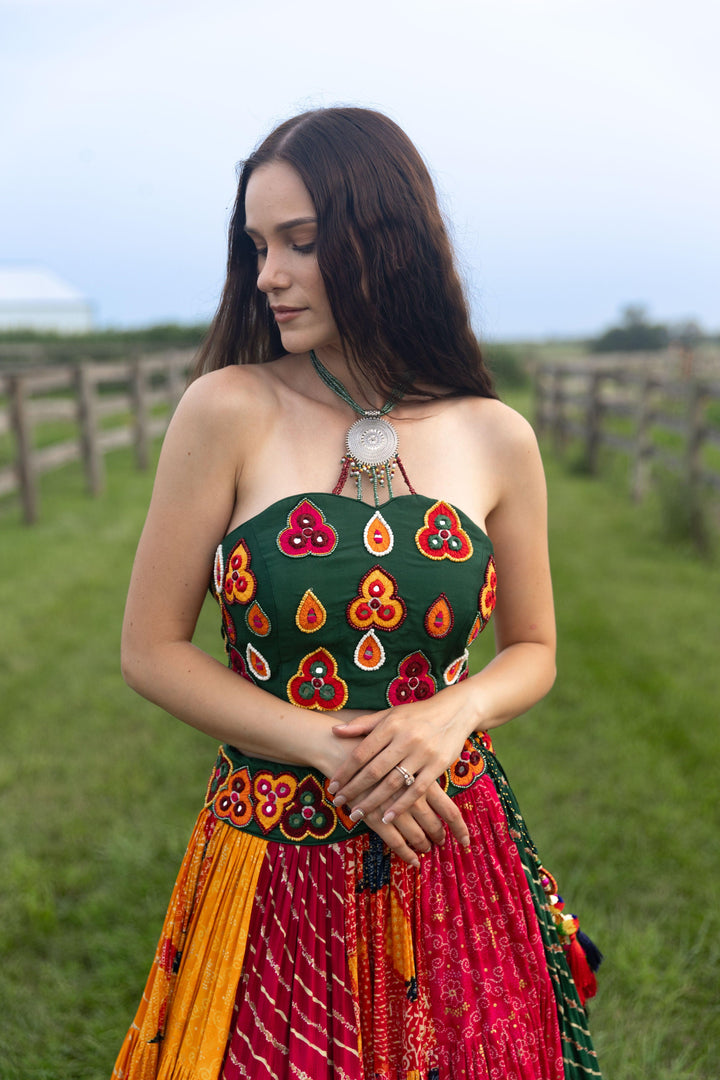 Woman in a multi-color cotton-silk Chaniya Choli set with an embroidered halter-neck blouse.