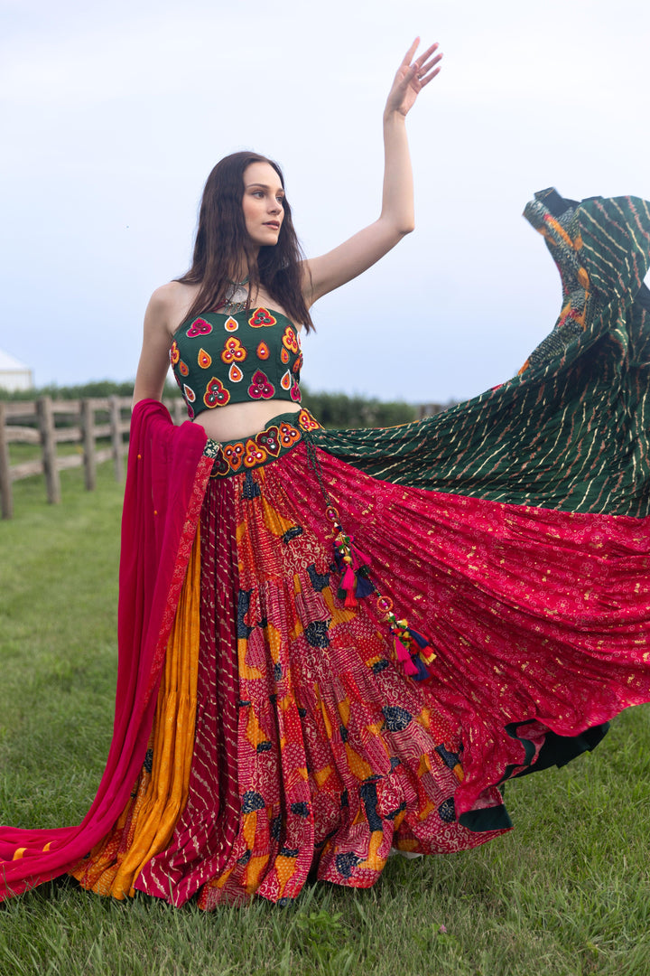 Woman in multi-color cotton-silk chaniya choli with dramatic flare, embroidered halter top, and red dupatta.