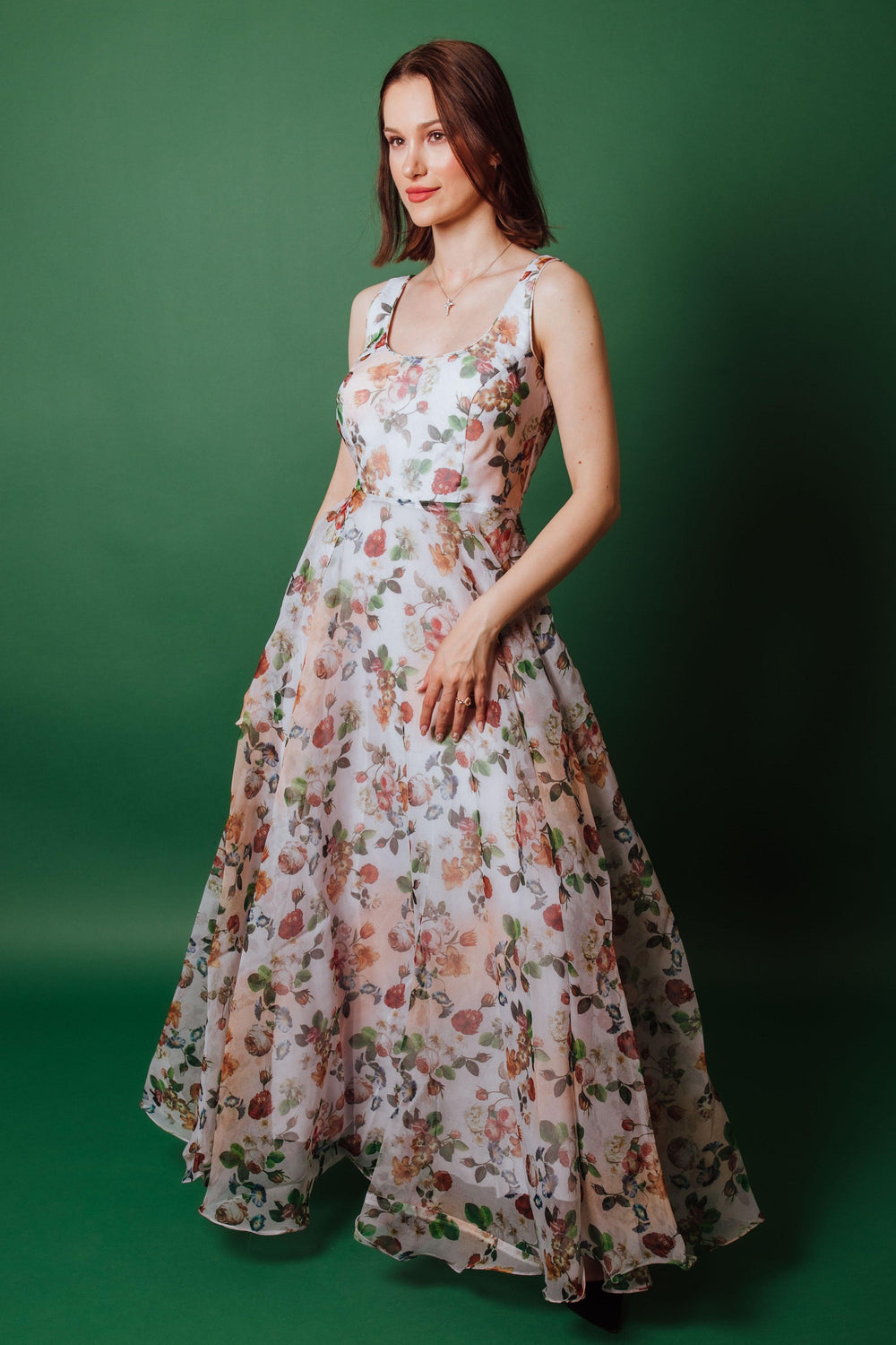 White organza floral gown with peach, coral, and sage roses, sleeveless, fitted bodice, and full skirt.