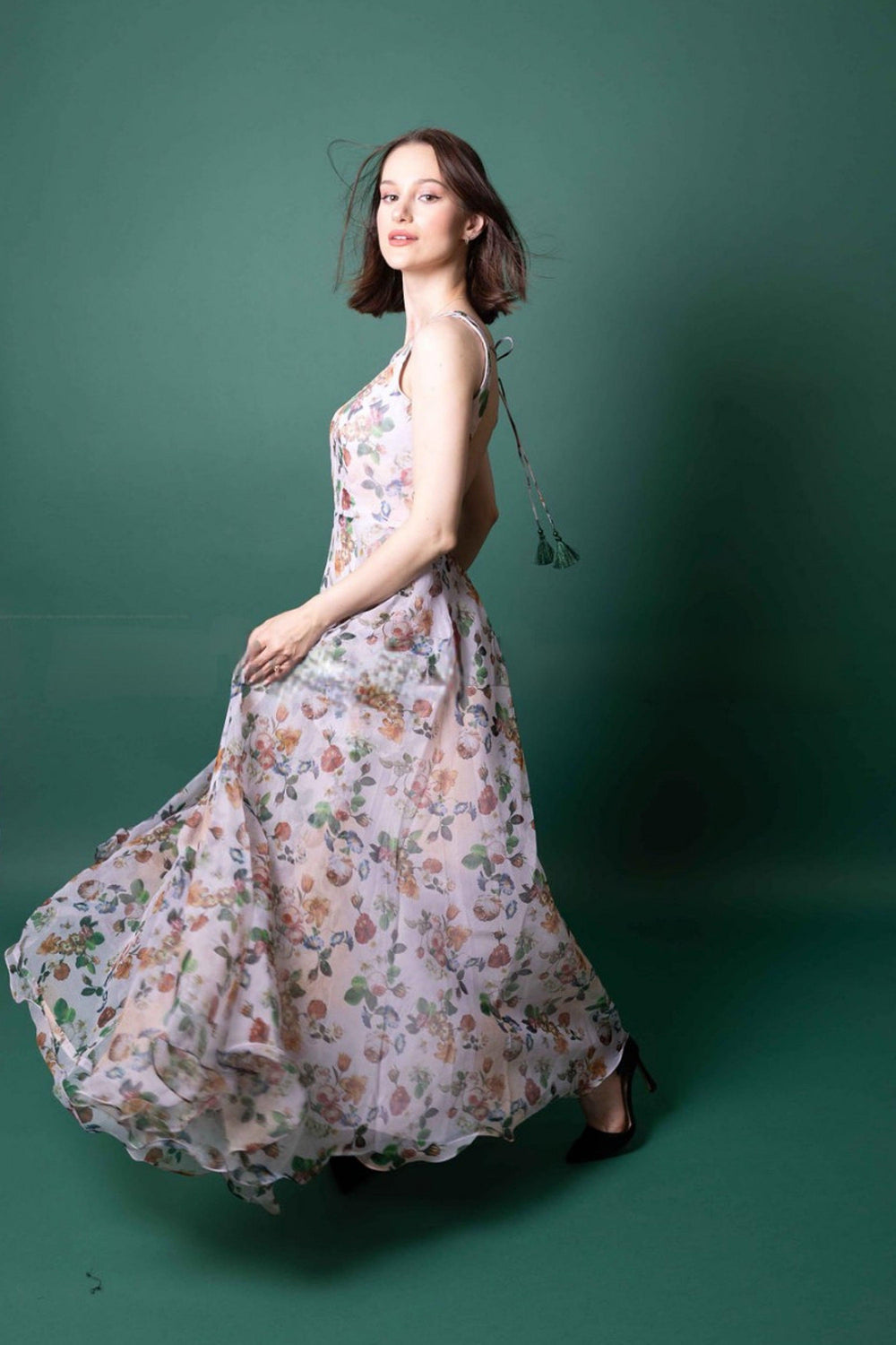 White organza gown with peach, coral, and sage floral print, sleeveless, open back, and full skirt.