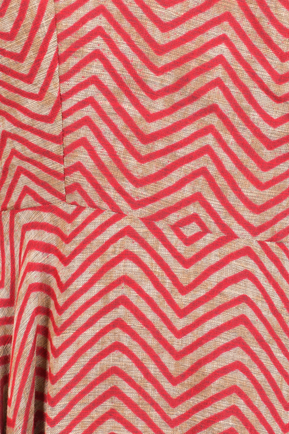Close-up of orange cotton maxi dress fabric with red chevron and diamond stripe patterns.