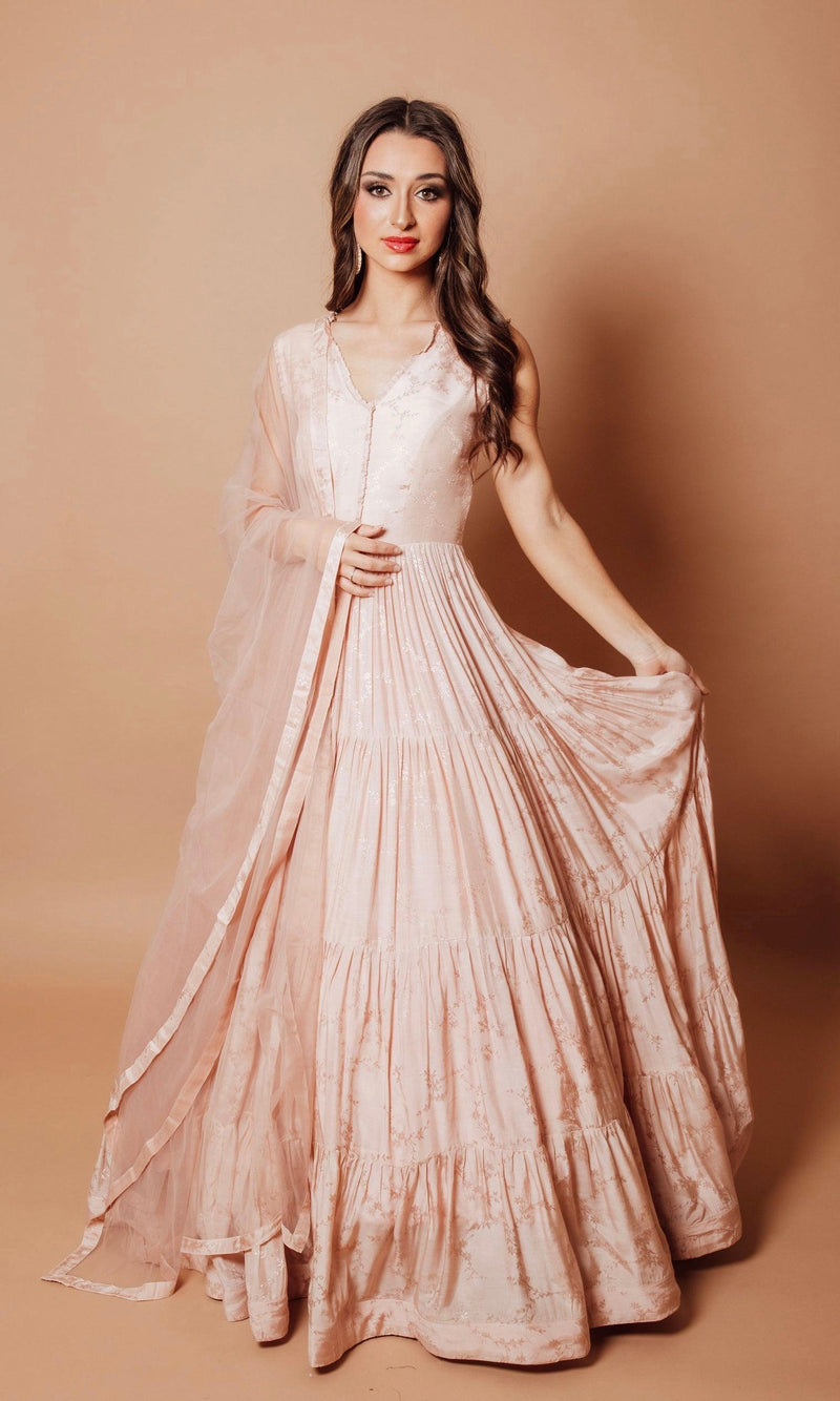 Blush pink jacquard silk tiered gown with self-woven floral pattern, V-neck, and sheer dupatta.
