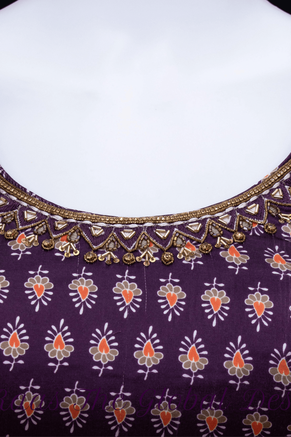 Close-up of a purple silk dress with intricate zardoshi, stone, and resham embroidery on the neckline.