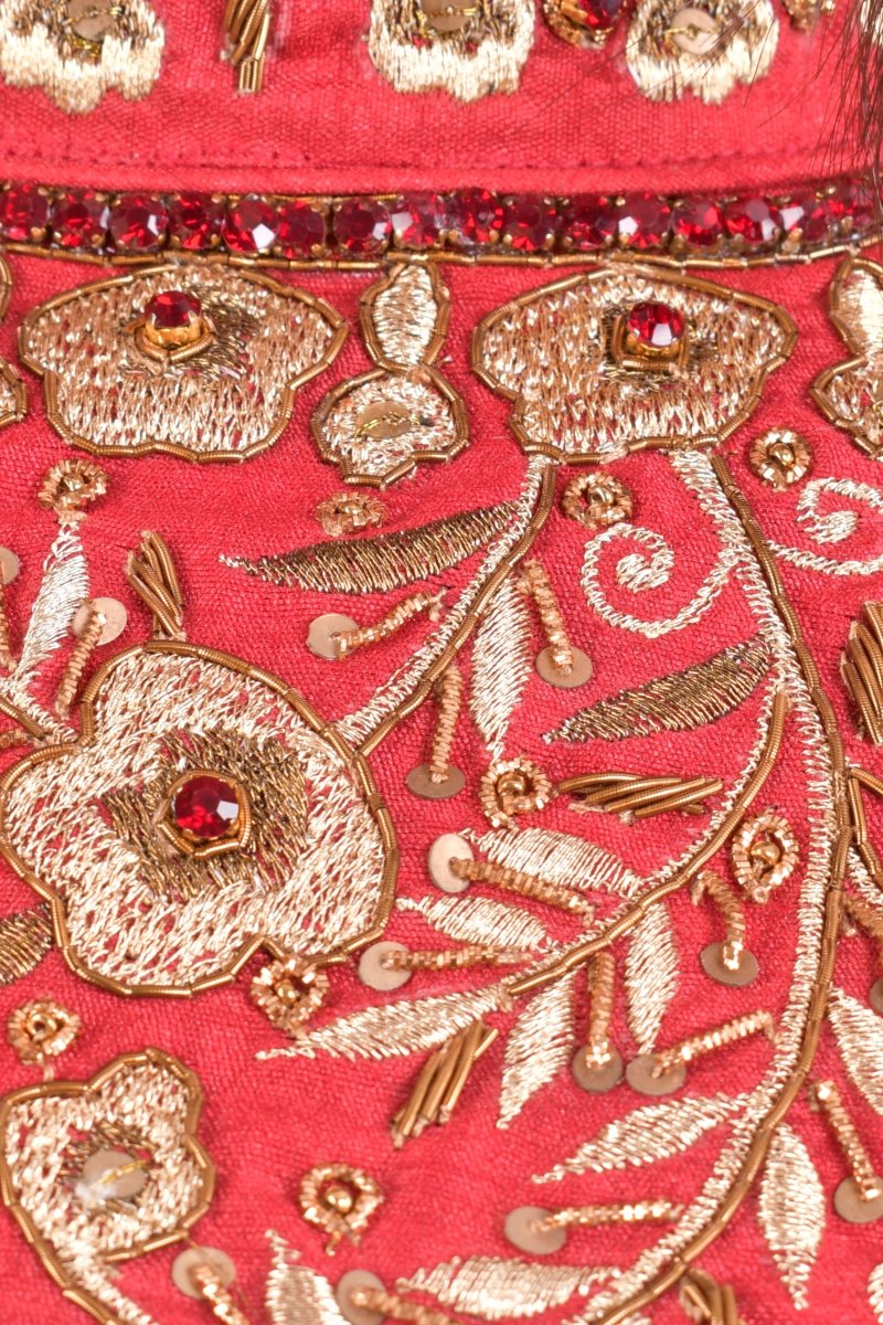 Close-up of a red raw silk gown with intricate gold resham, kasab, and stone floral embroidery.
