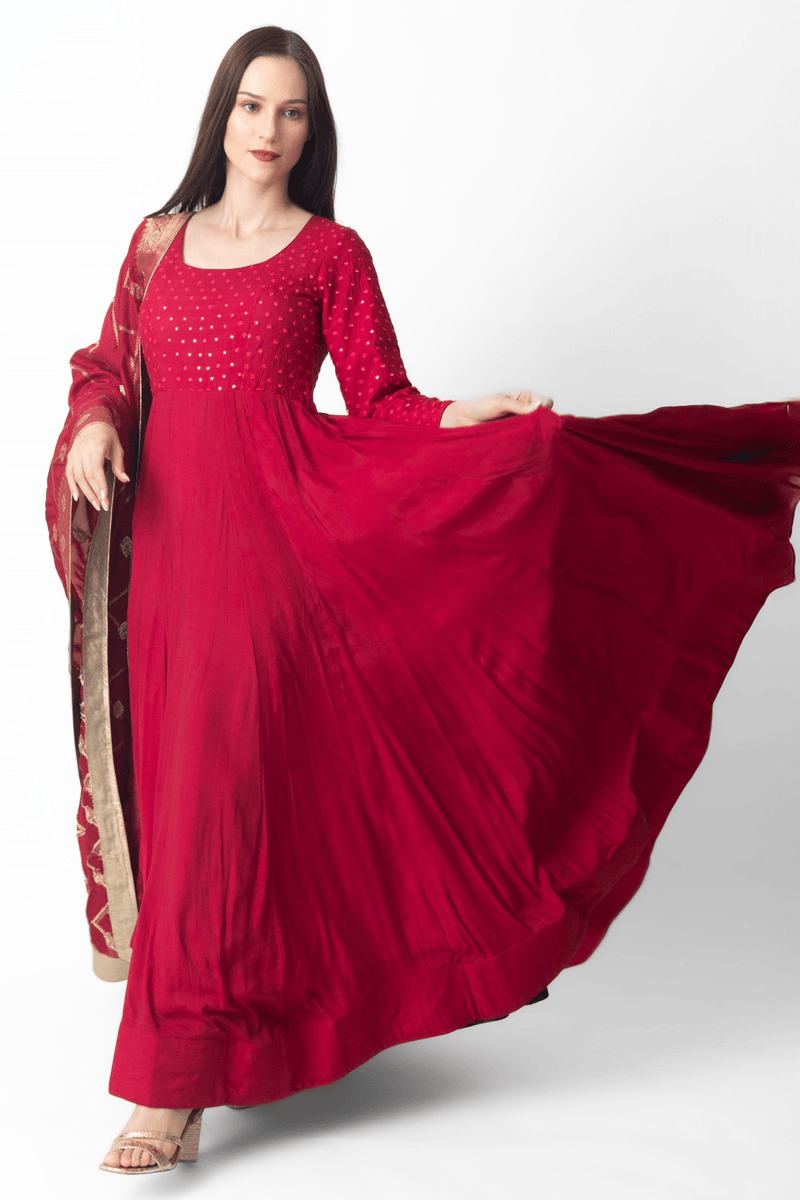 Red silk gown with intricate mirror embroidery, full sleeves, and matching Banarasi dupatta.