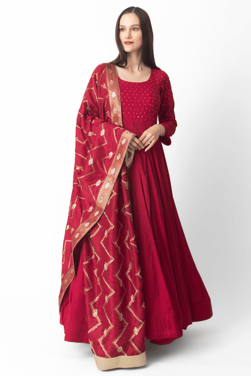 Red silk gown with intricate mirror embroidery, full sleeves, and a matching Banarasi dupatta.