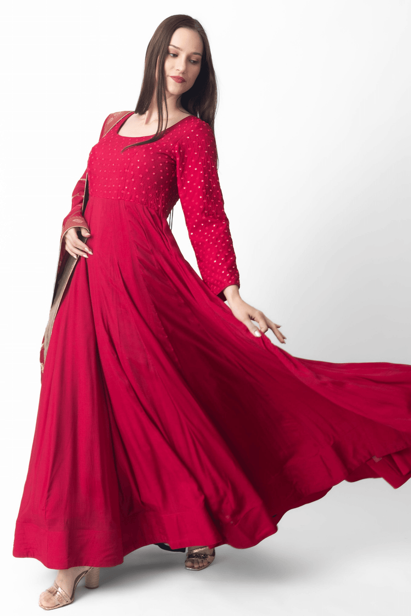 Red silk gown with intricate mirror embroidery, full sleeves, and matching Banarasi dupatta.