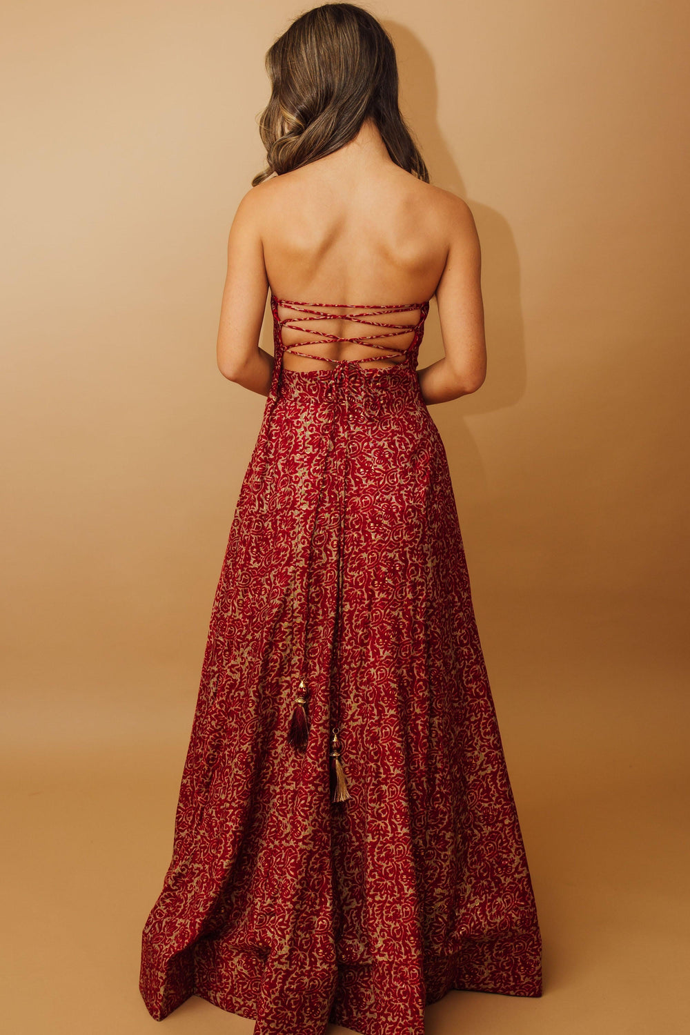 Red cotton-silk off-shoulder long dress with intricate embroidery and patterned design, viewed from the back.