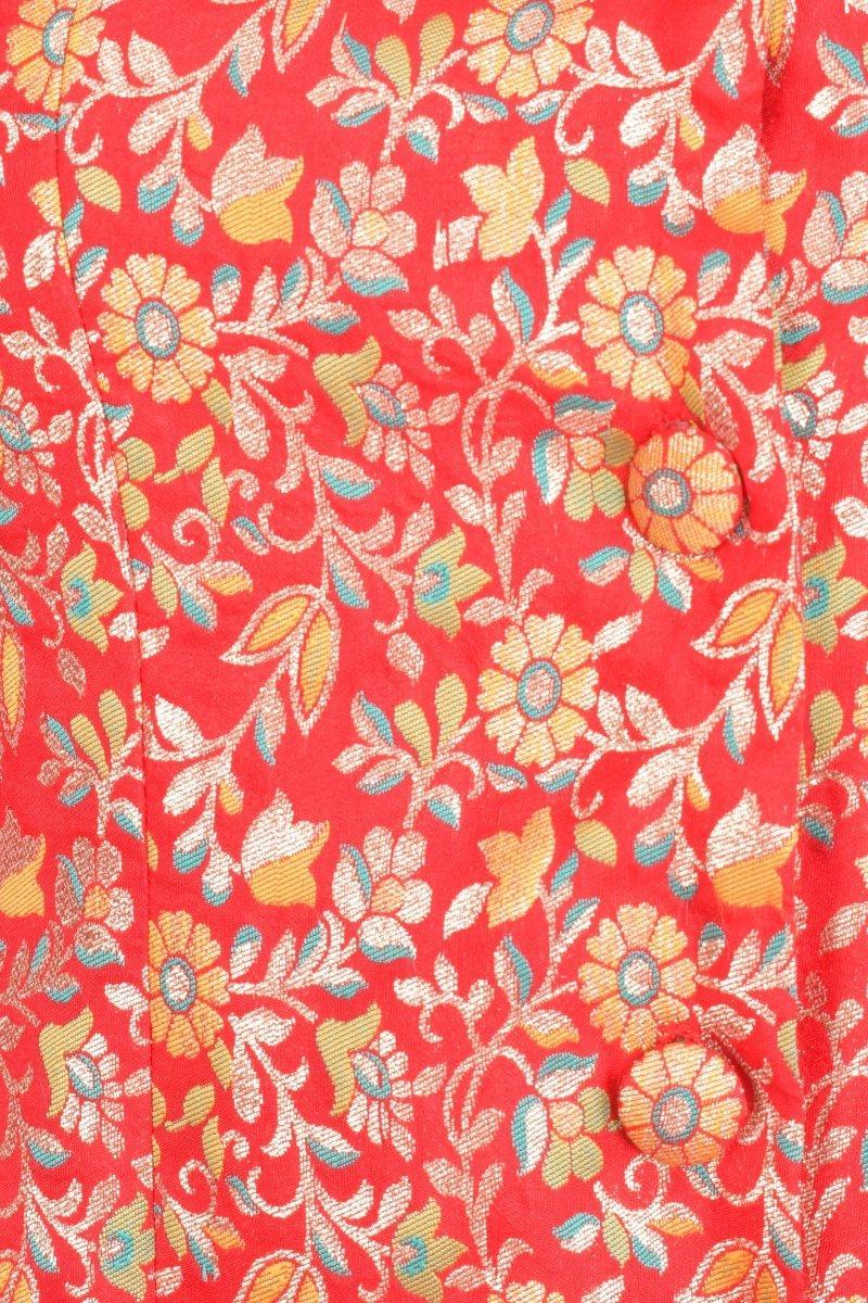 Close-up of a red silk jacquard blazer dress with gold floral brocade and matching fabric-covered buttons.