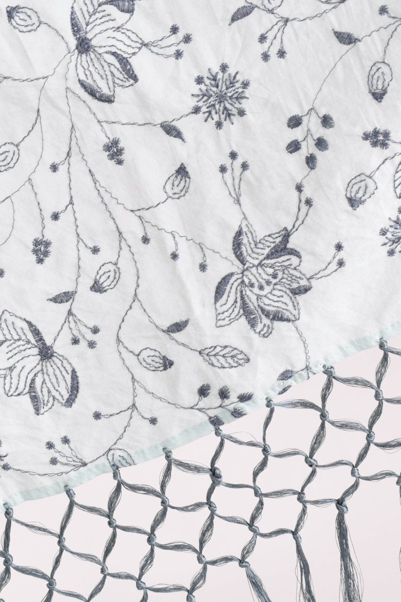 Sage green mul cotton scarf with intricate floral embroidery and handcrafted tassels, perfect for comfort and elegance.