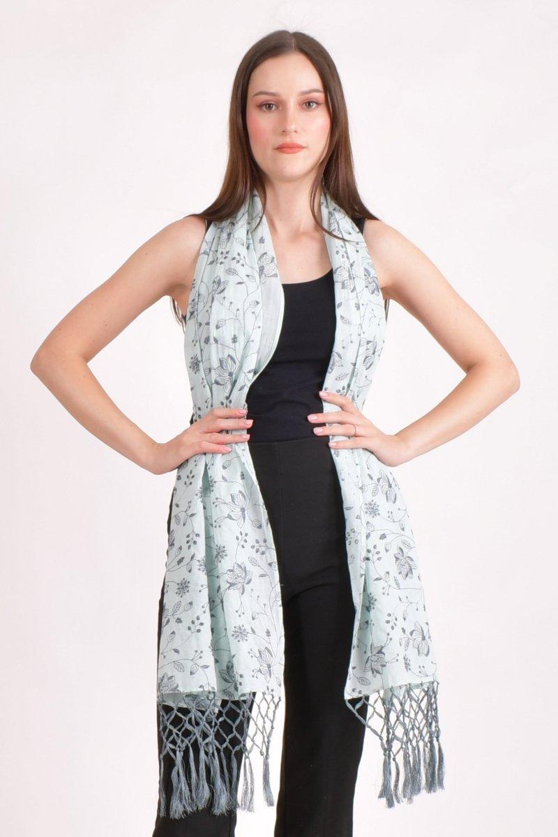 Sage green mul cotton scarf wrap with all-over floral embroidery and handcrafted tassels, worn by a model.