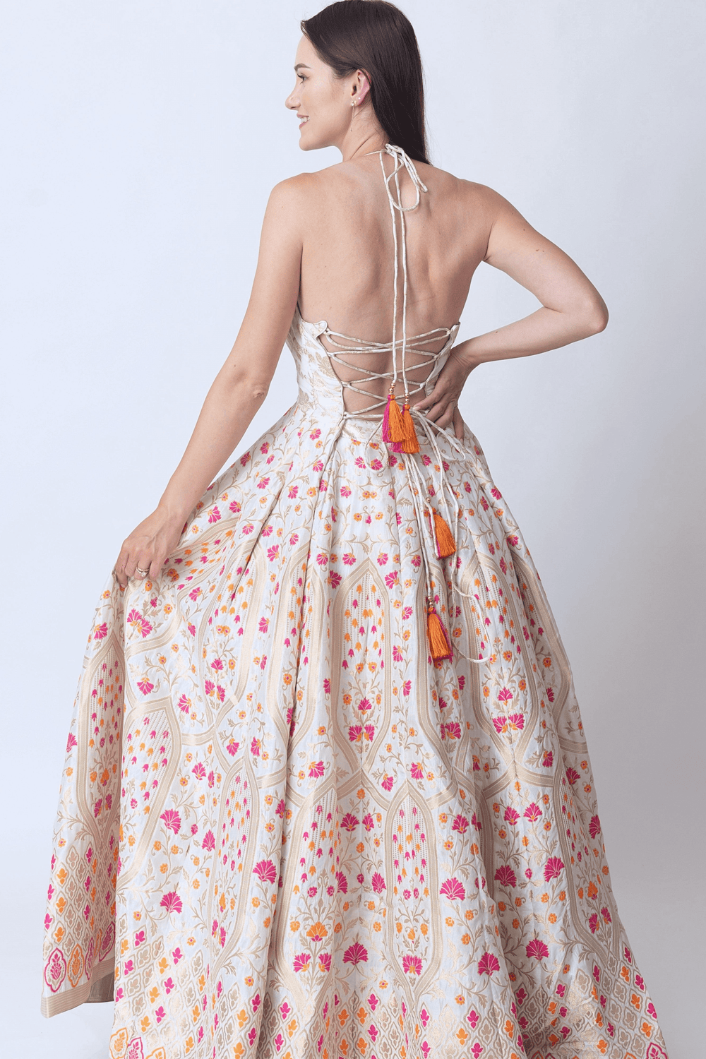 Matte gold beige silk jacquard gown with orange and pink floral patterns, sleeveless, back zipper, and tassels.