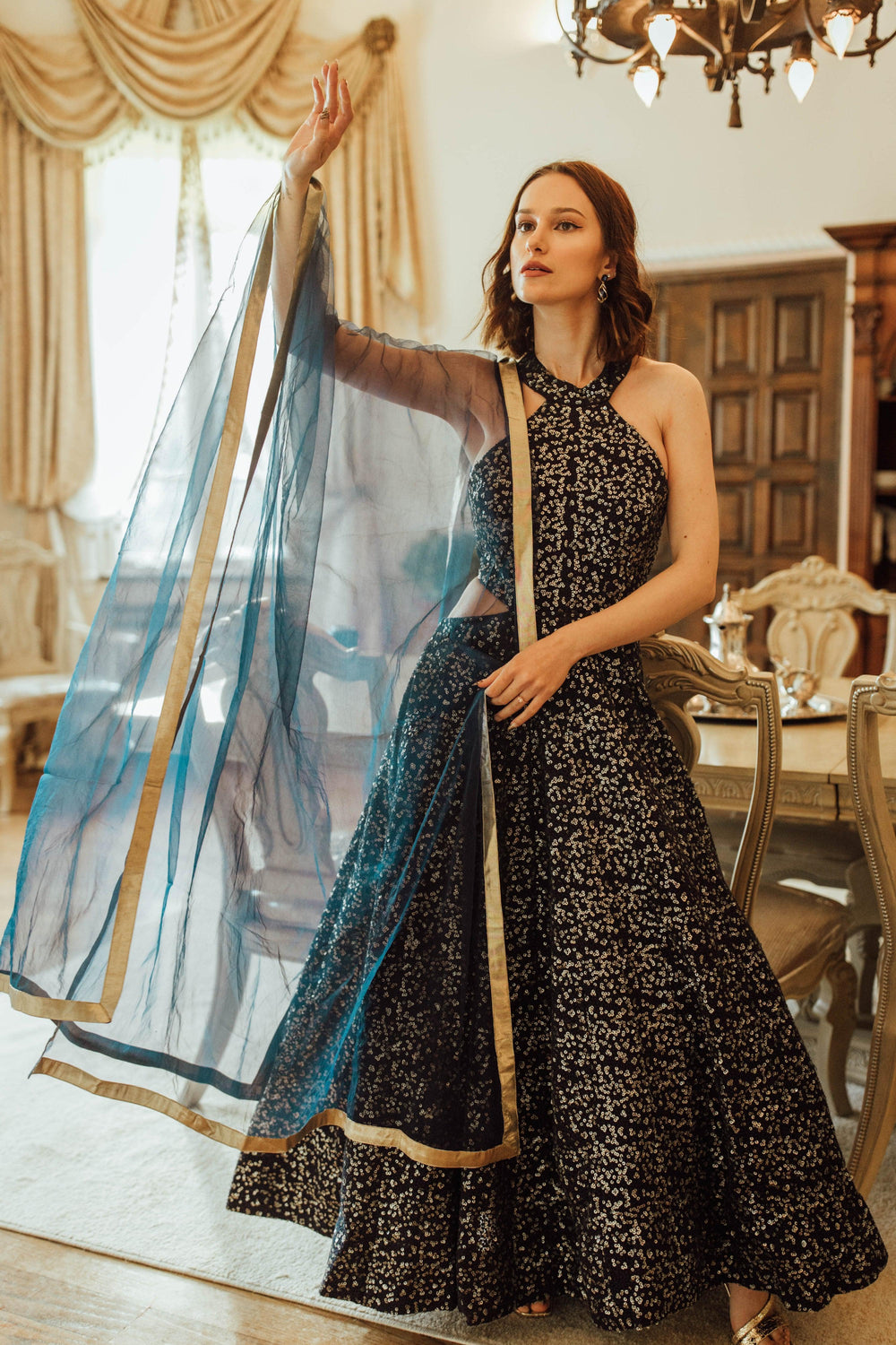 Stella Navy Blue Gown with all-over sequins embroidery, halter neck, and a net drape with golden border.