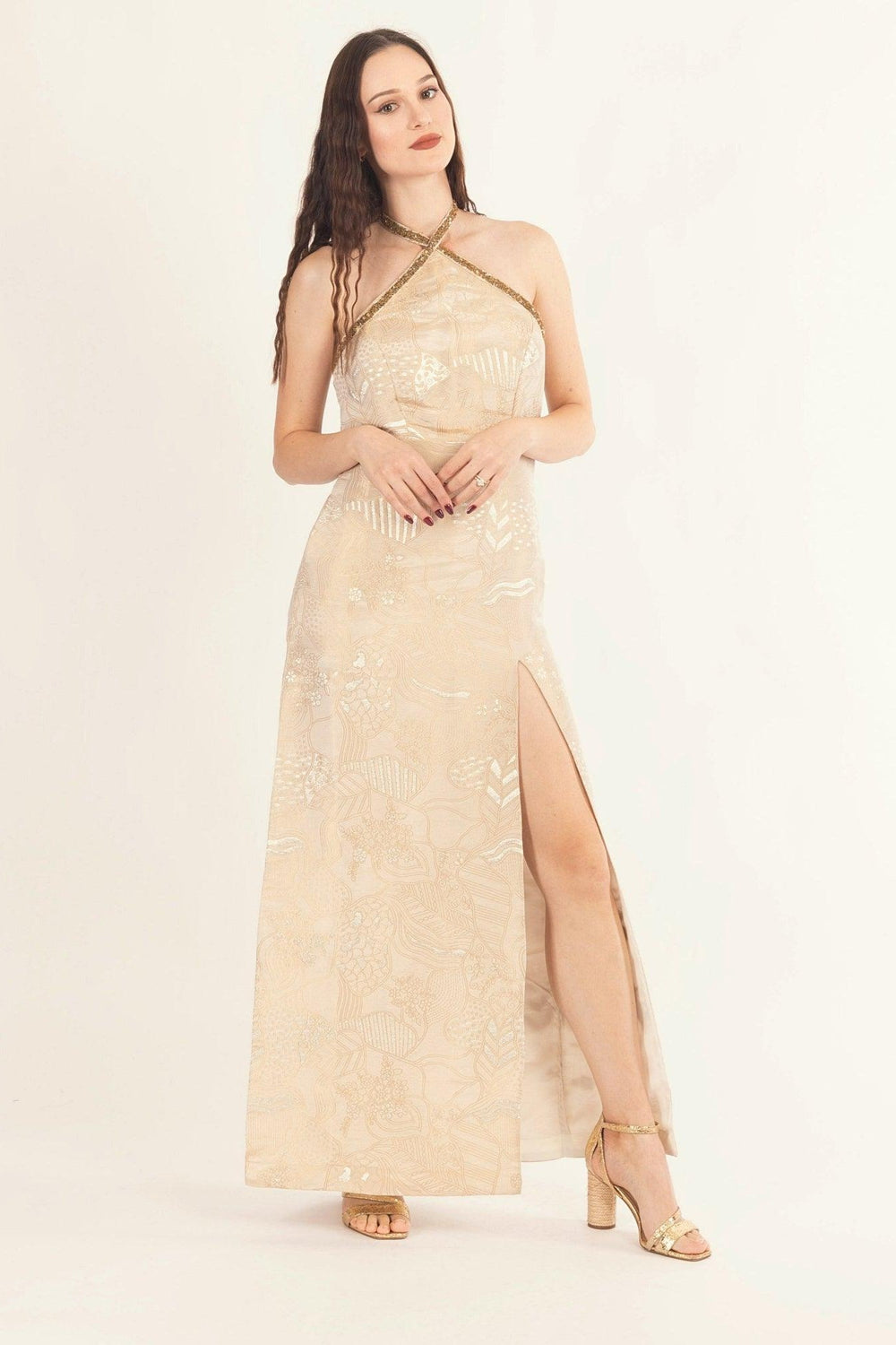 Tan jacquard silk halter long dress with all-over patterns, hand-embroidered neckline, and left leg slit.
