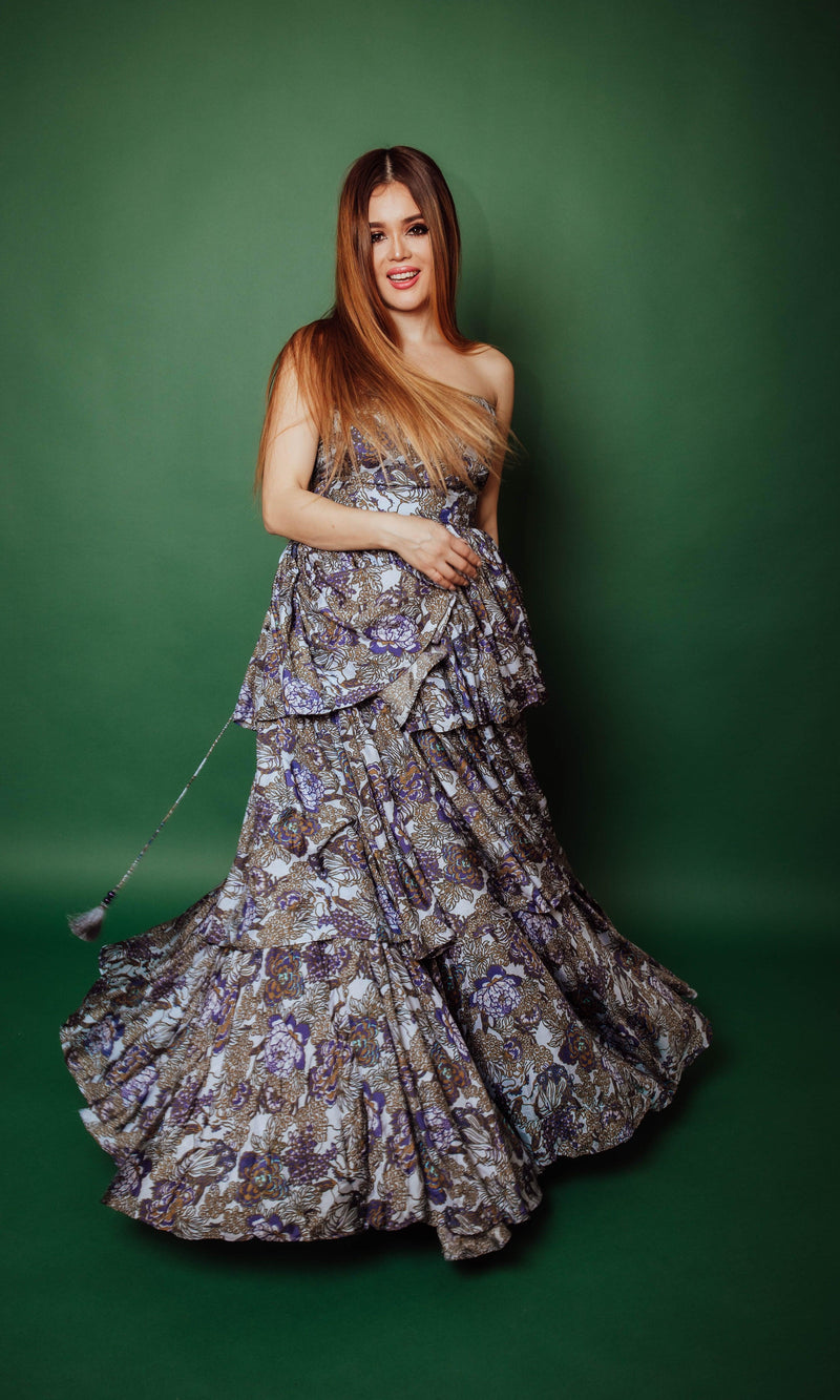 Silk tiered floral convertible long dress with micro-pleating, worn strapless against a green background.