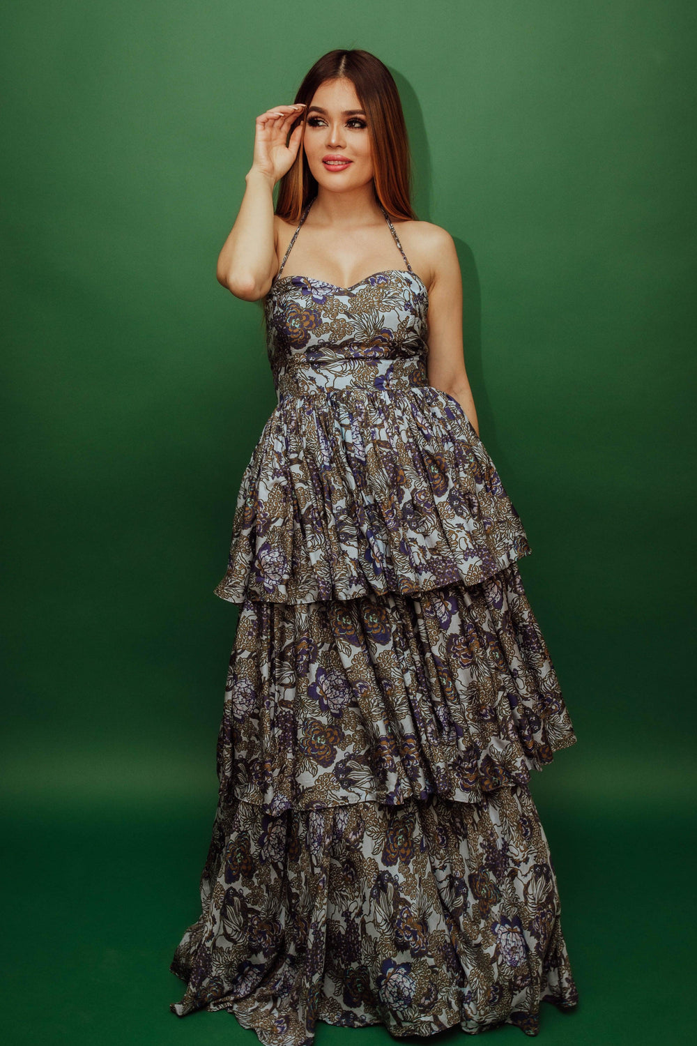 Silk tiered floral convertible long dress with micro-pleating, worn over shoulders.