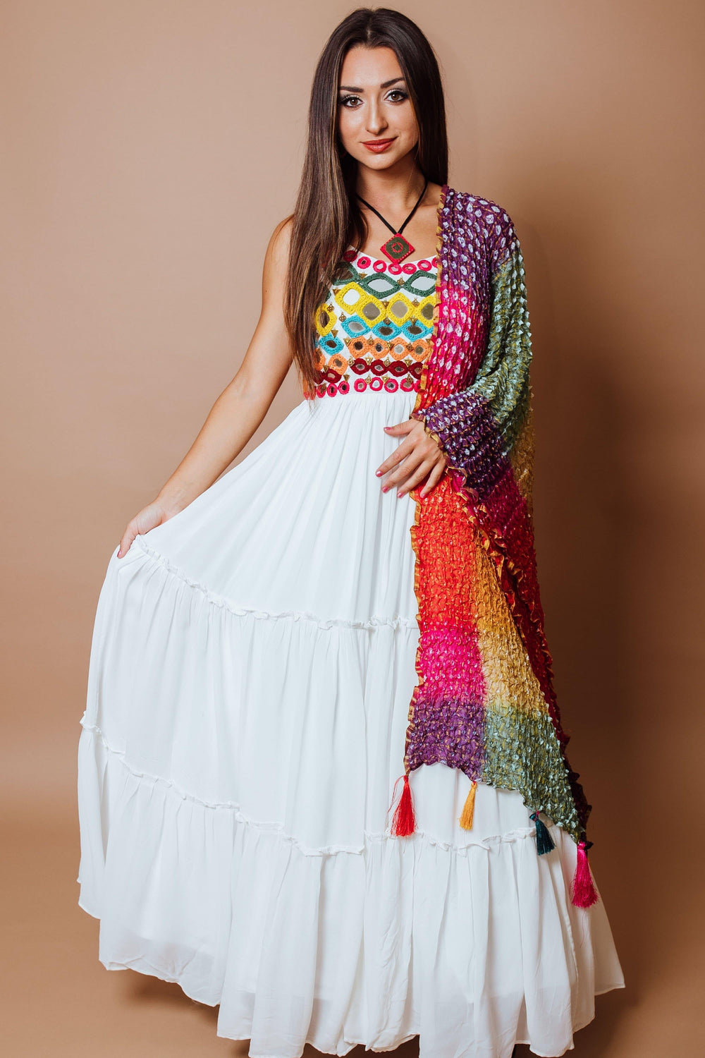 White tiered georgette gown with vibrant anchor and mirror work bodice, paired with a multicolor ombre silk drape.