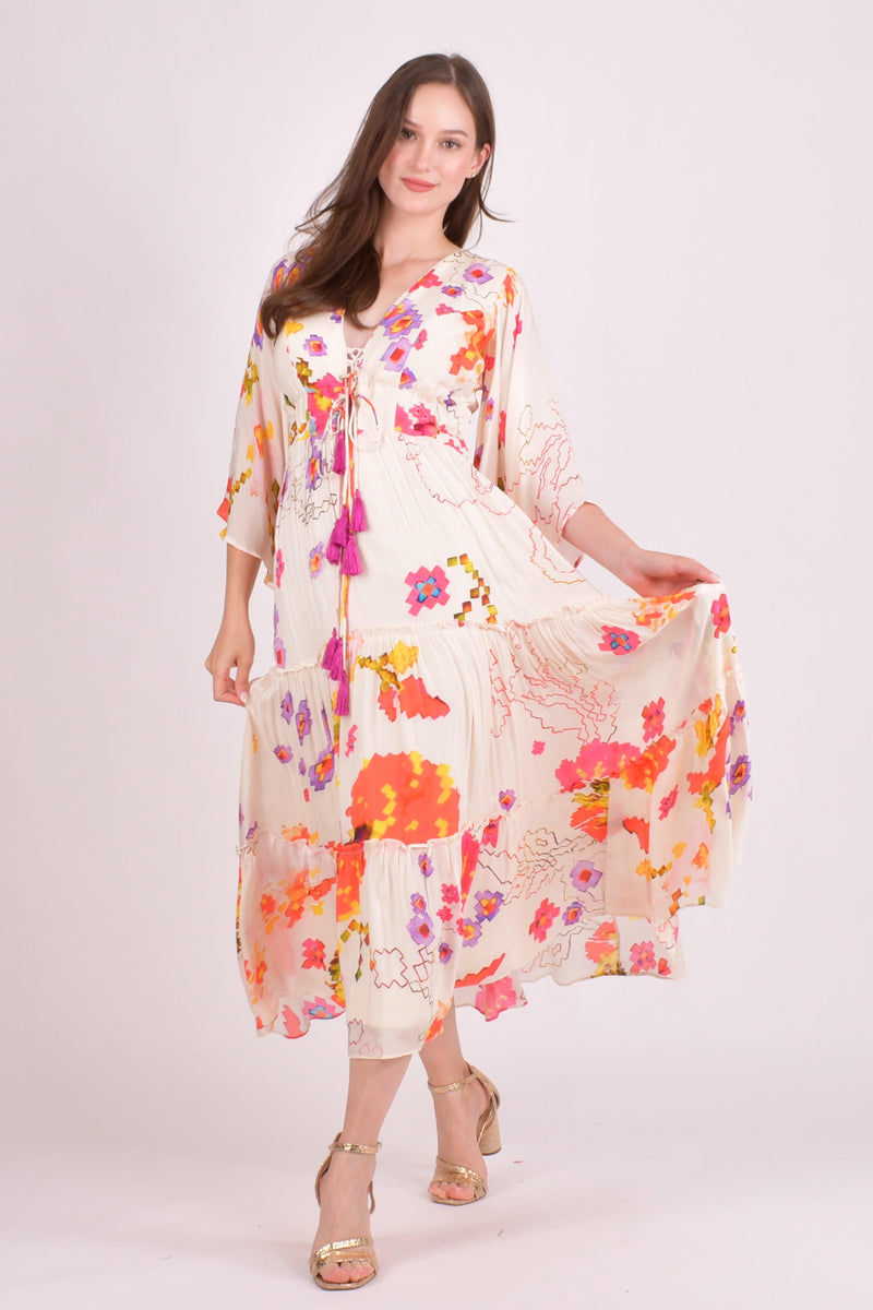 White floral ruffle maxi dress with watercolor prints, angel sleeves, and tassel details.