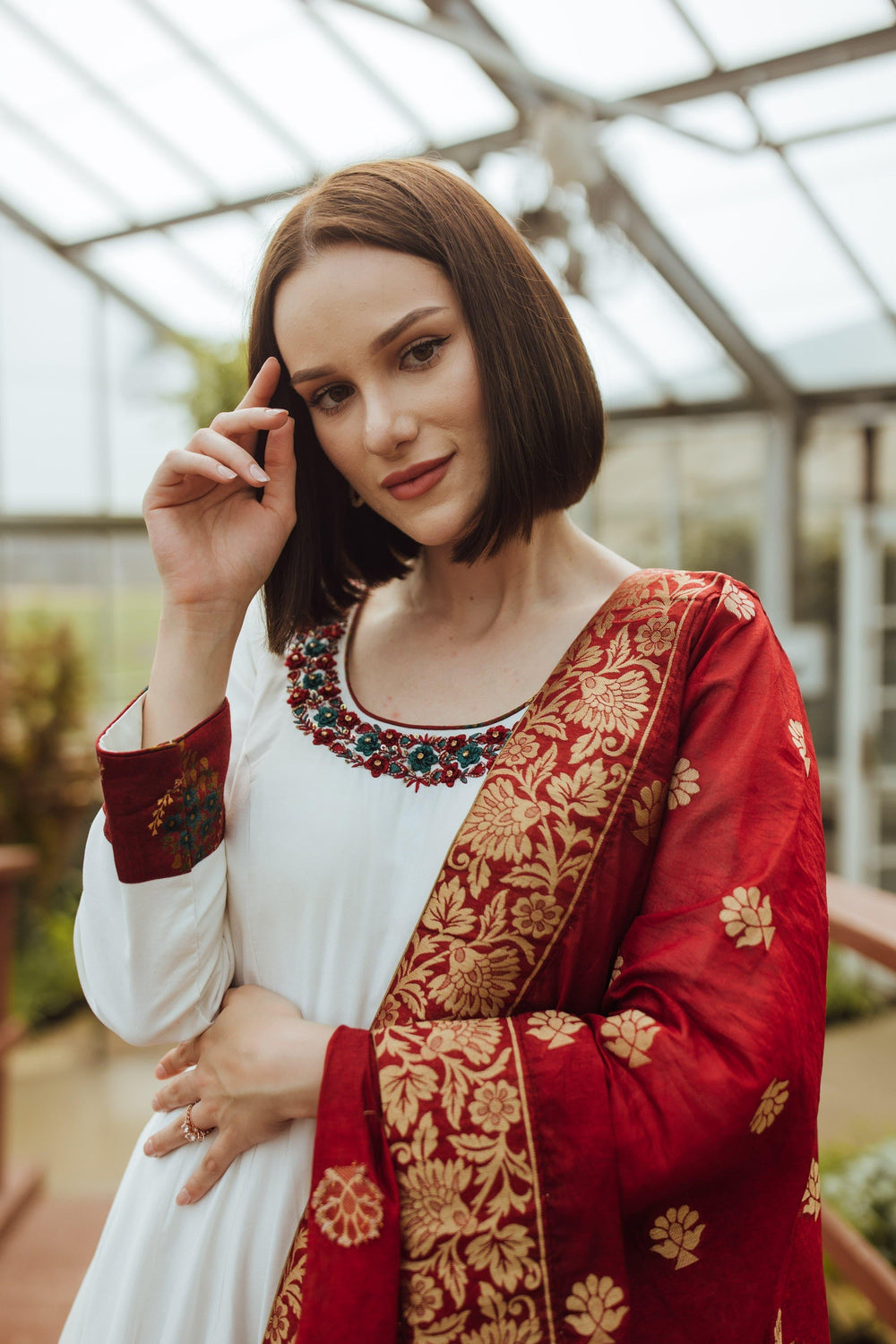 White silk long dress with red resham and gold embroidery, paired with a crimson Banarasi silk drape.