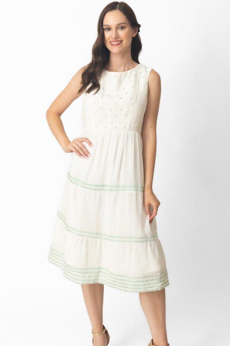 White midi dress with sleeveless bodice, tiered skirt, and delicate green hand-embroidered patterns.
