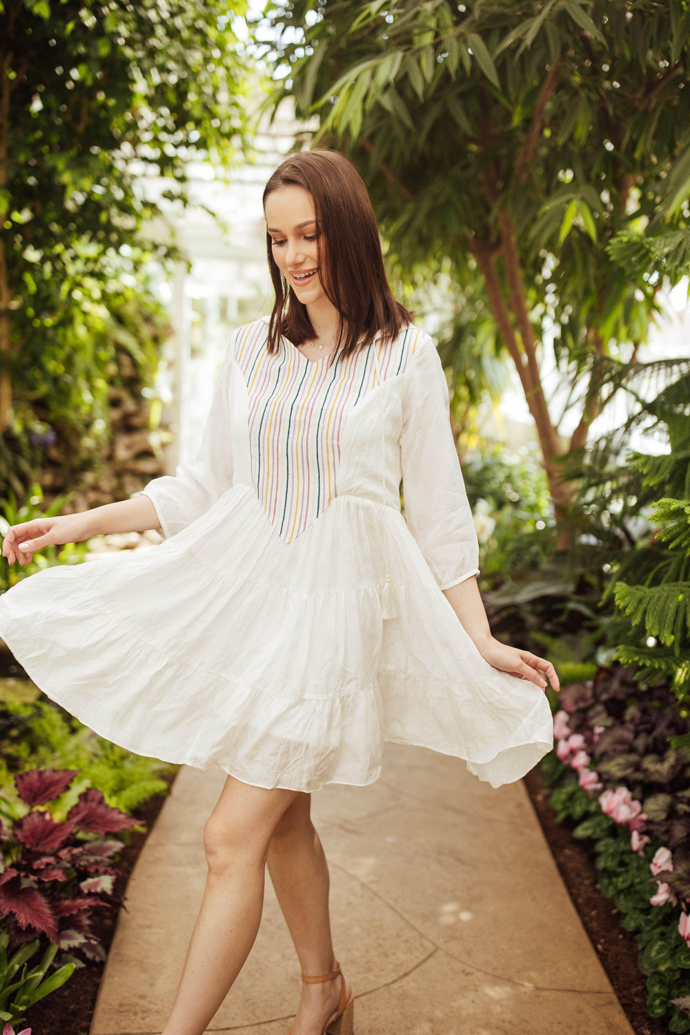 White cotton tiered mini dress with colorful resham embroidery, 3/4 sleeves, and a hood.