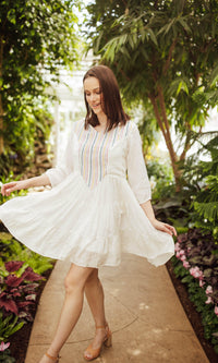White cotton tiered mini dress with colorful resham embroidery, 3/4 sleeves, and a hood.