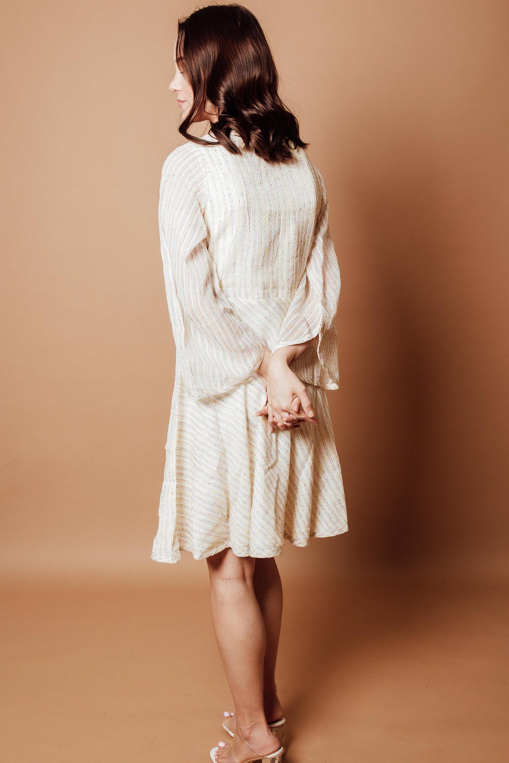 Off-white georgette wrap dress with subtle patterns, full sleeves, and all-over sequins, viewed from the back.