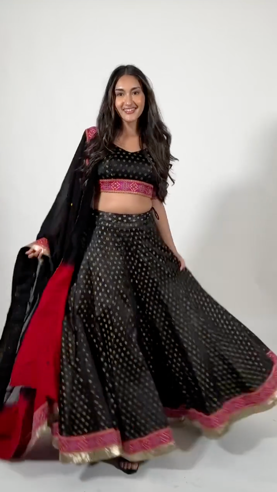 A model twirling and showcasing Endora Black Lehenga Choli by Raas