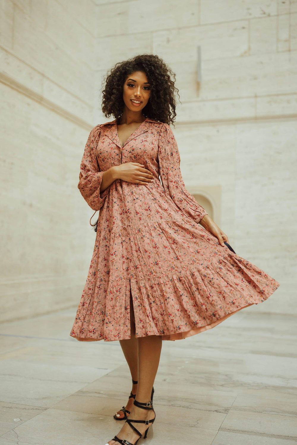 Pink tiered midi dress with long sleeves and floral print, worn by a model.