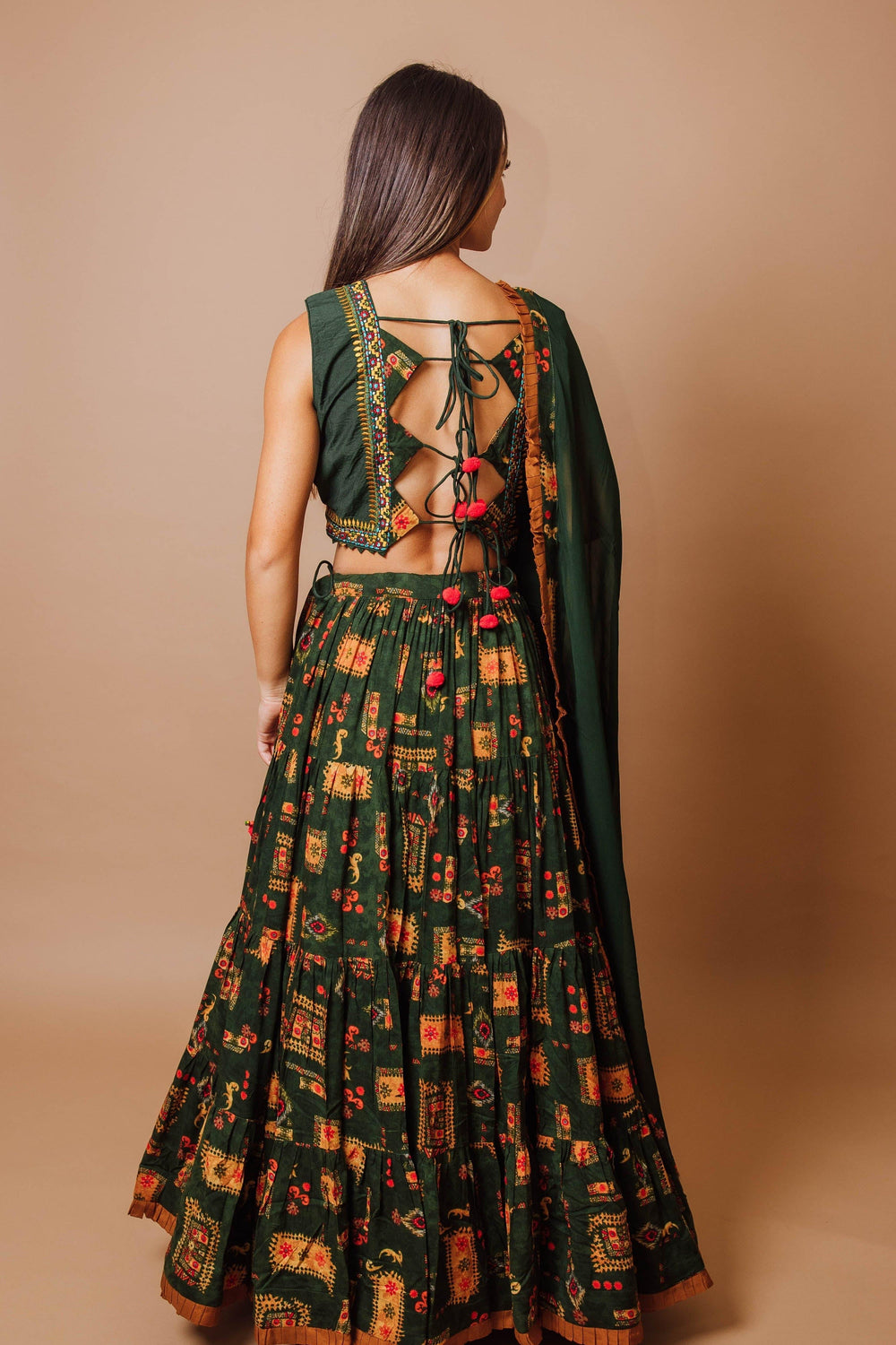 Green tiered rayon lehenga choli with open-back blouse, string ties, and dupatta. Perfect for Garba.