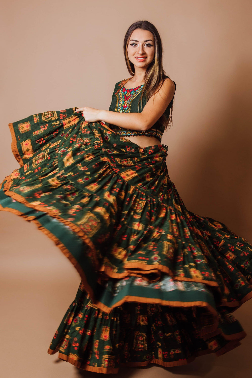 Green tiered rayon lehenga choli set with hand embroidery, shown in a dramatic twirl, perfect for Garba.