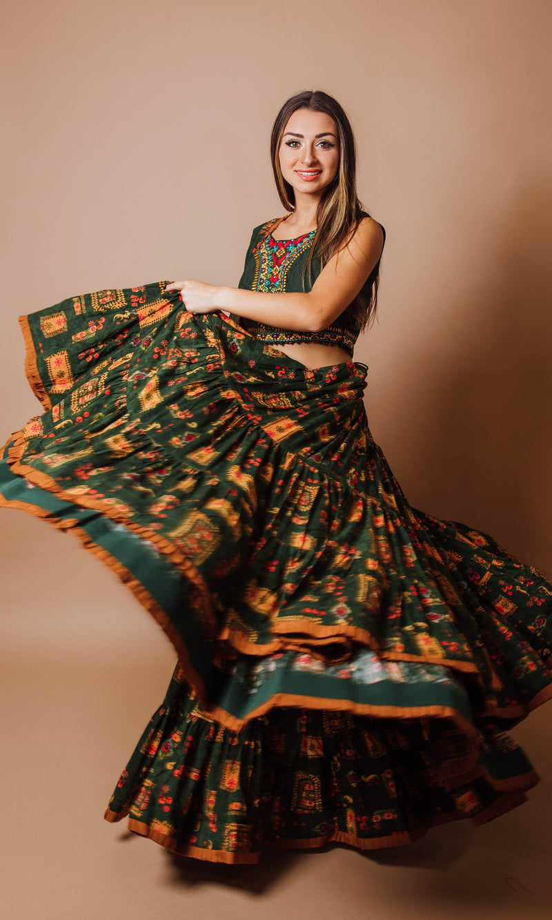 Green tiered rayon lehenga choli set with hand embroidery, shown in a dramatic twirl, perfect for Garba.