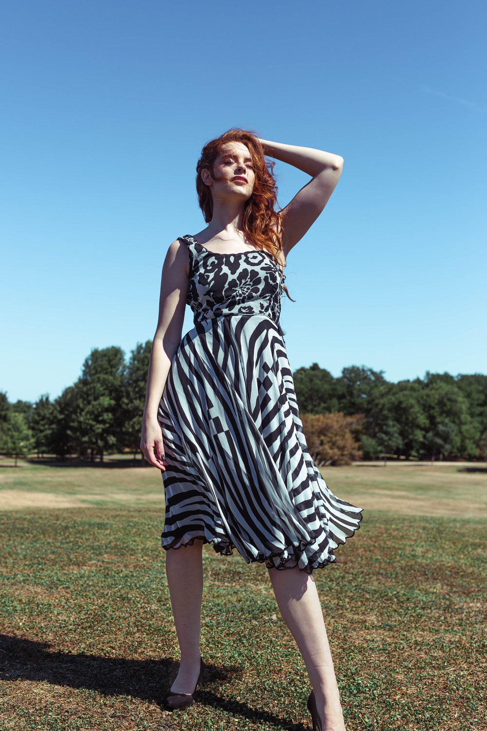 Grey georgette midi dress with black floral, paisley, and zebra prints, sleeveless, round neck.
