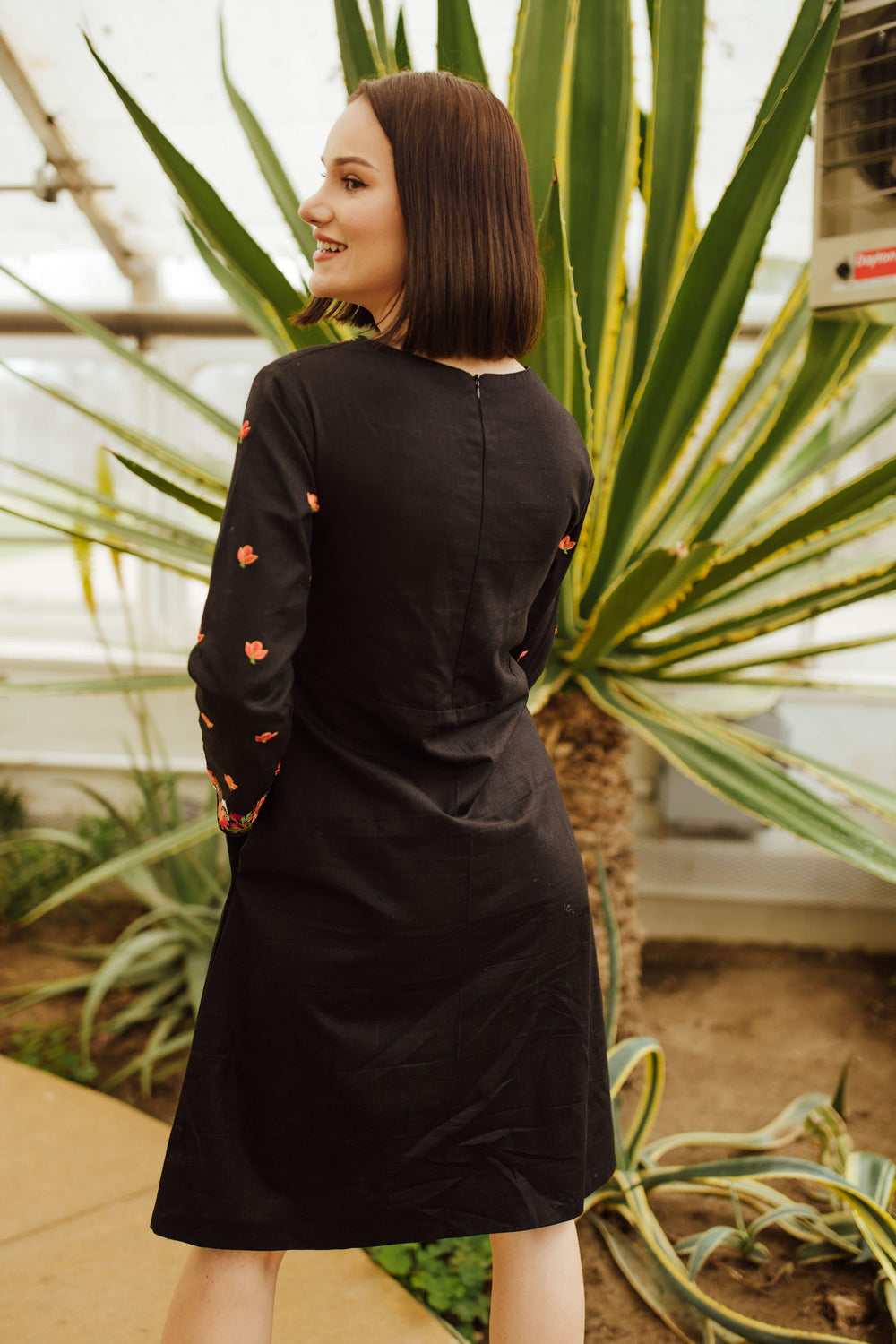 Leila black cotton midi dress with intricate floral embroidery on sleeves, back zipper, and full sleeves.