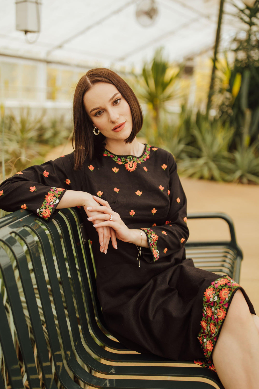 Leila black cotton midi dress with vibrant floral embroidery on neckline, sleeves, and hem.
