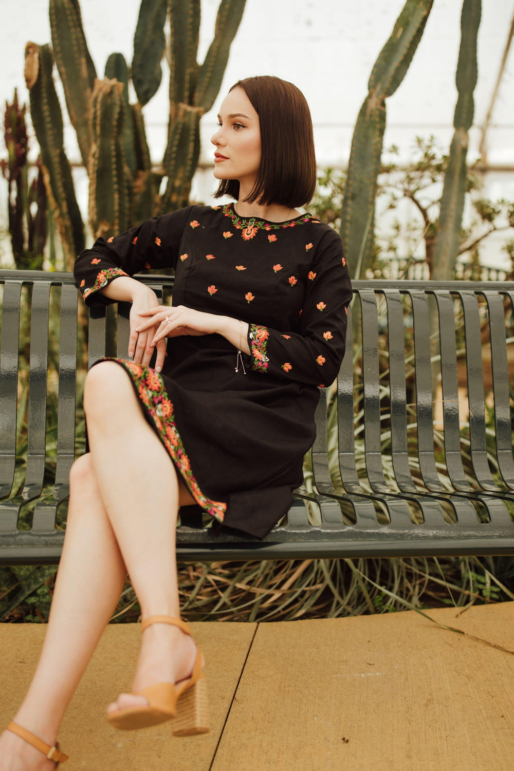 Leila black cotton midi dress with intricate floral embroidery on neckline, sleeves, torso, and hem.