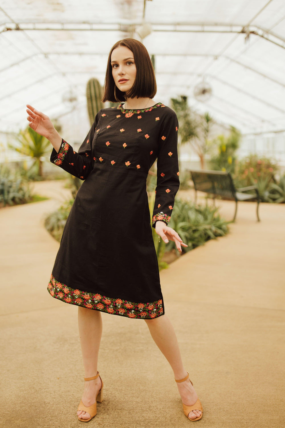 Leila black cotton midi dress with intricate floral embroidery on neckline, sleeves, torso, and hem.