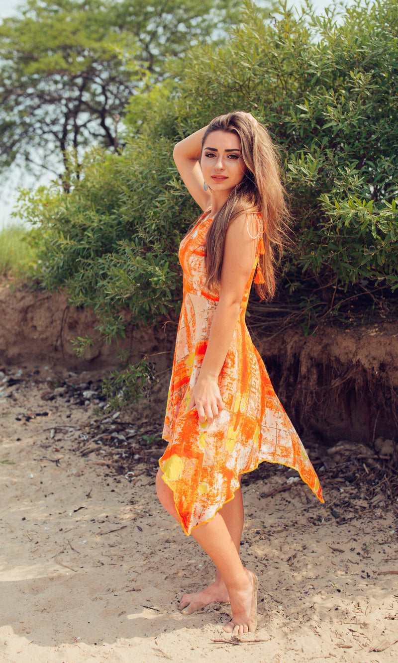 Tawny orange viscose rayon high-low dress with vibrant tie-dye patterns, V-neckline, and fluid silhouette.