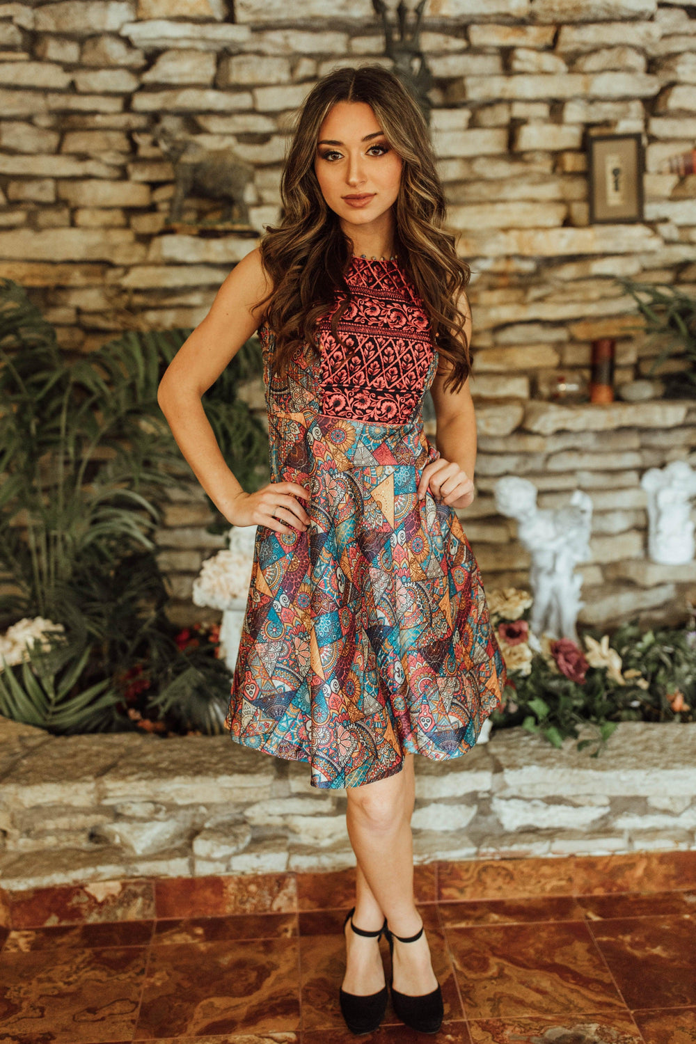 Sleeveless mini dress with red and gold embroidered bodice and colorful geometric-print circle skirt.