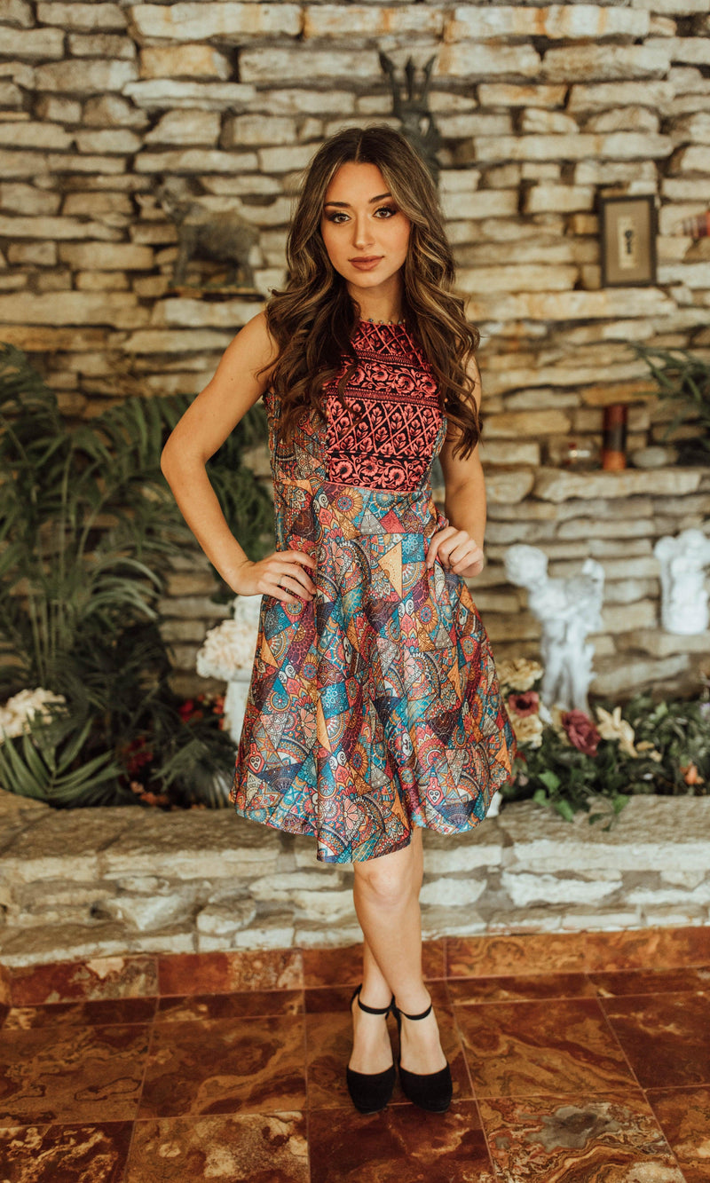 Sleeveless mini dress with red and gold embroidered bodice and colorful geometric-print circle skirt.