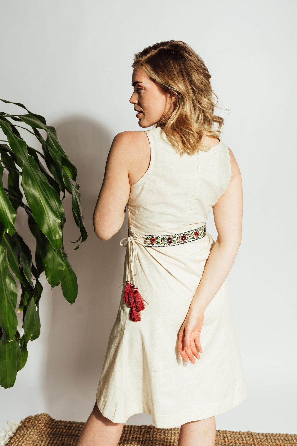 Off-white flex cotton midi dress with intricate thread embroidery on the torso and a red floral embroidered waistband.